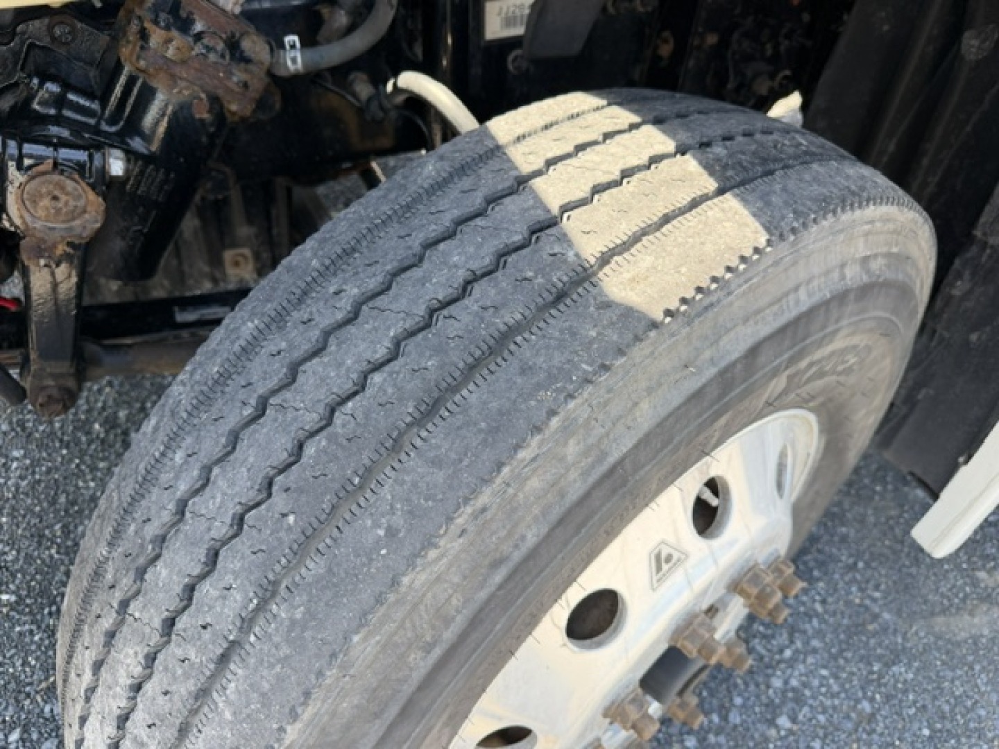 Front wheel and tire of a 2018 Freightliner Cascadia CA125DC showing tread wear and wheel rim, partial suspension components visible.