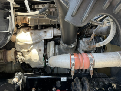 Engine bay of a 2018 Freightliner Cascadia CA125DC showing turbocharger, intake manifold, exhaust, hoses, and pipe with hose clamp.