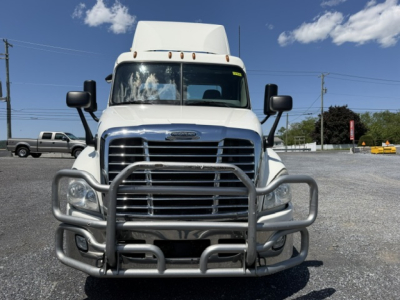 Front view of a 2018 Freightliner Cascadia CA125DC conventional daycab truck with a heavy-duty grille guard and chrome bumper, showing the front chrome grille and headlights.