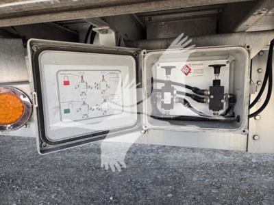 Trailer electrical outlet access panel showing wiring diagram and control box on a drop deck trailer.