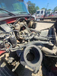 Engine bay with air intake elbow and various hoses on a Sterling Acterra truck, showing engine components and wiring in the foreground.