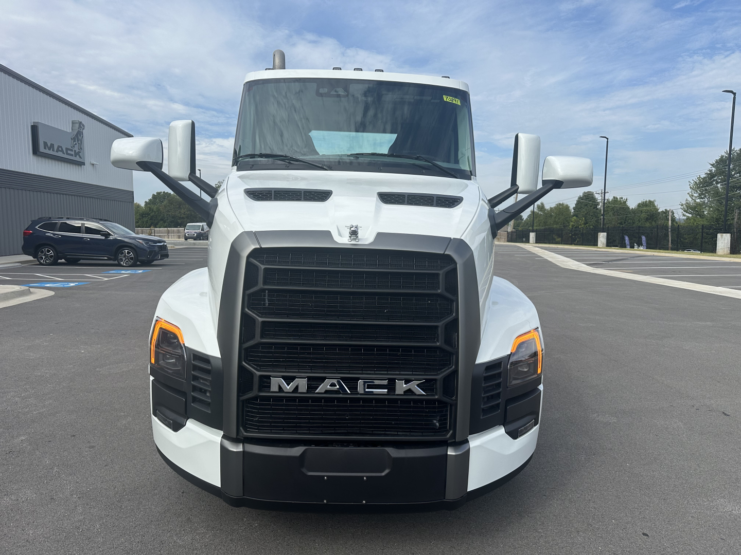 Front view of a white 2026 Mack PR64T conventional daycab truck showing large black grille, Mack emblem, and headlights.