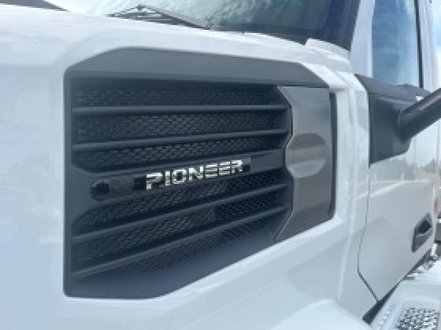 Pioneer grille of a white 2026 Mack PR64T truck cab showing front grille with Pioneer emblem.