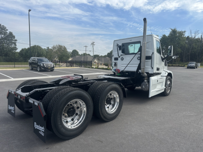 Mack PR64T daycab tractor with white cab and dual rear axles, showing fifth-wheel area and side exhaust stacks.