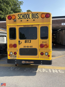 Rear view of a yellow school bus with 'SCHOOL BUS' signage, Collins logo, emergency exit window, and contact numbers on the back.