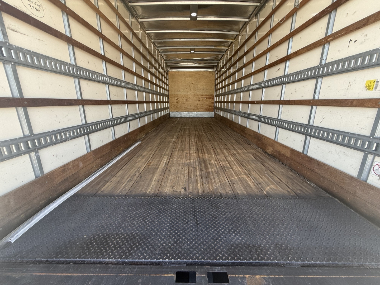 Freightliner M2 cargo box interior showing empty long box with wooden floor and side reflectors.