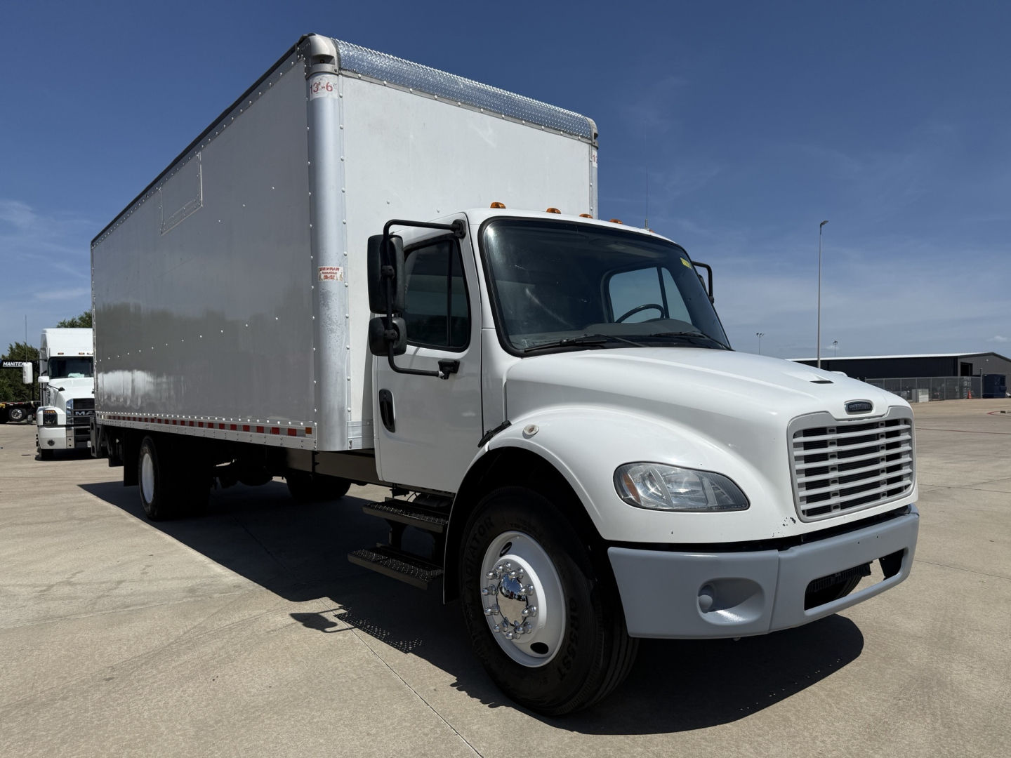 Freightliner M2 box truck in service showing cab and large cargo box.