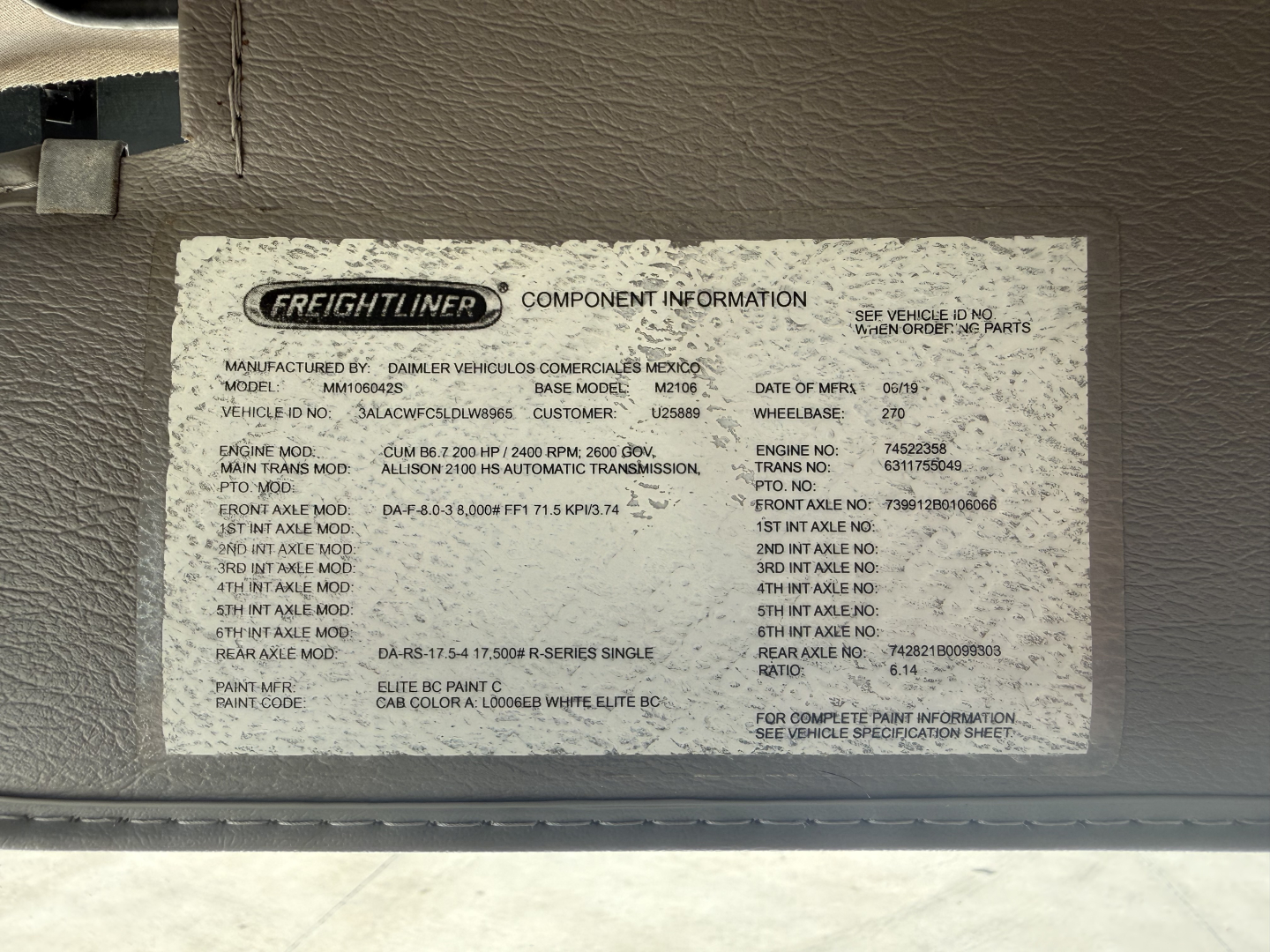 Freightliner M2 component information sticker in engine bay, listing model, base model, manufacturing details, VIN partial, and various specification fields.