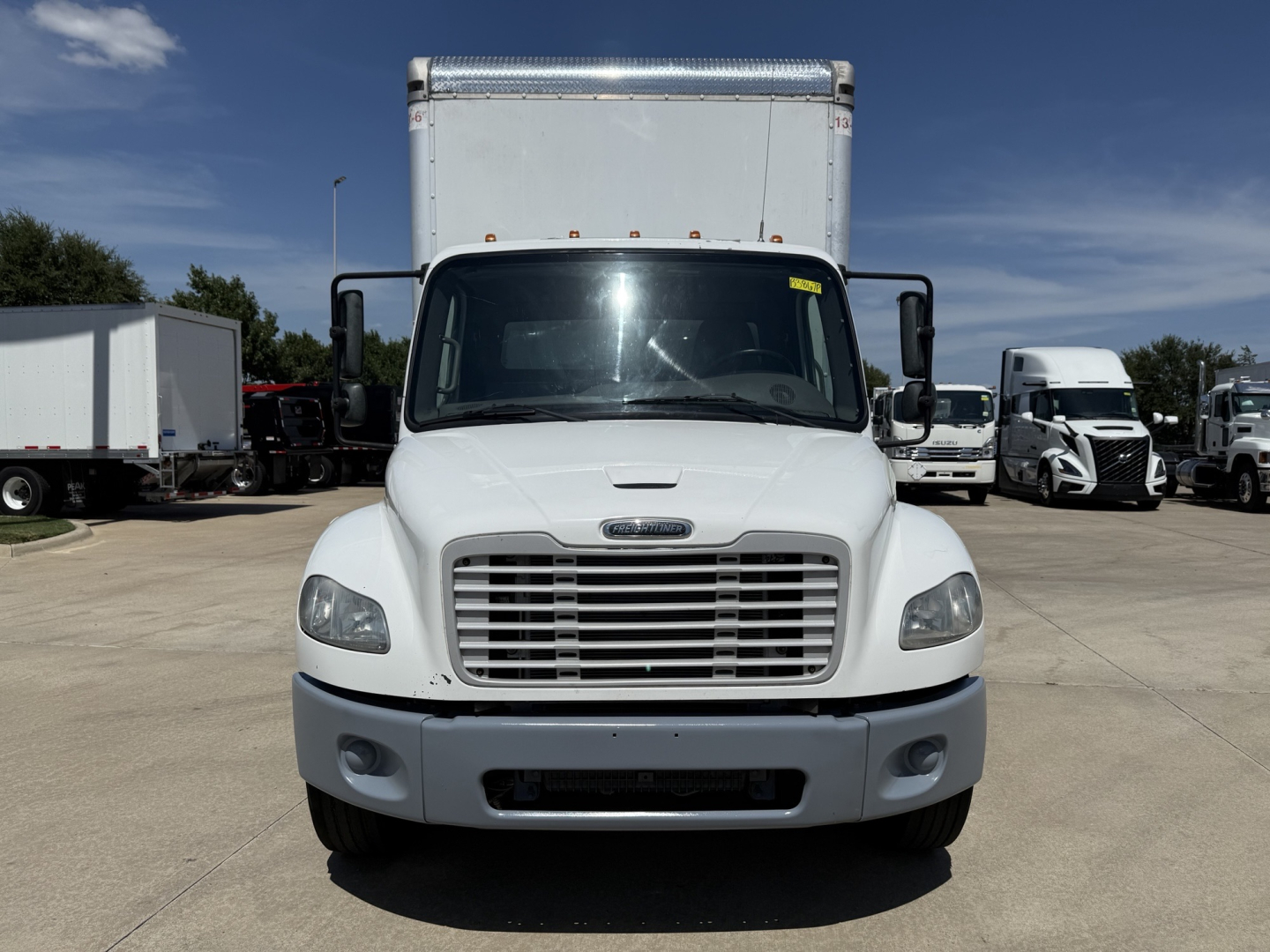 Freightliner M2 box truck front view showing grille, headlights, bumper, and cab with large windshield.