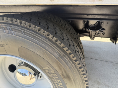 Tandem rear wheel and dual tires from Freightliner M2 showing tire tread and chassis components