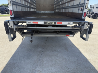 Freightliner M2 truck rear view showing liftgate platform and tailboard with Maxon label and hydraulic components.