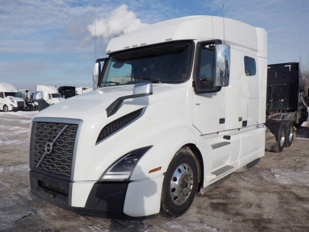 Volvo VNL 740 sleeper cab truck in a lot, white exterior, large grille, aerodynamic mirrors, and side steps visible.