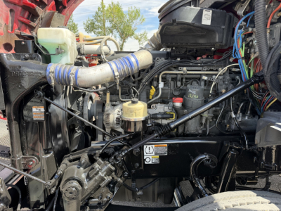 Kenworth T880 engine bay with visible hoses, wiring, and engine components; includes coolant reservoir and various labels.