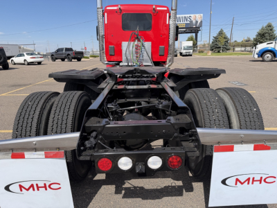 Kenworth T880 rear view showing chassis and dual rear axles, with wiring, lights, and hitch components.
