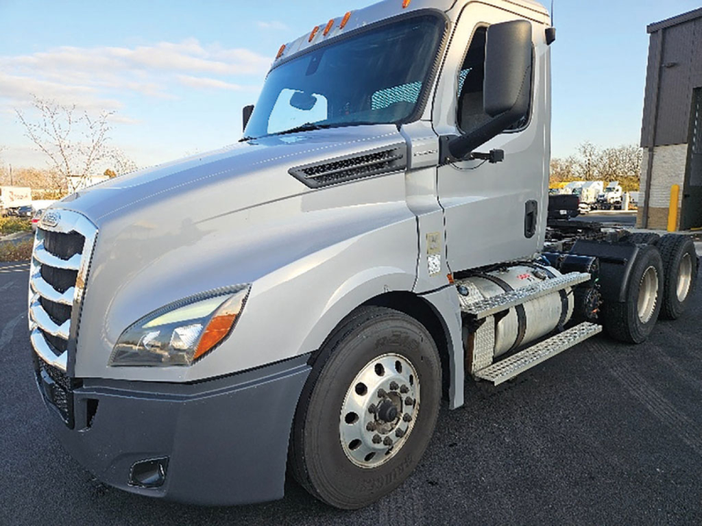 Truck side view of a 2020 Freightliner Cascadia126 cab with silver paint, showing front grille, headlight, and wheel, Daycab configuration.