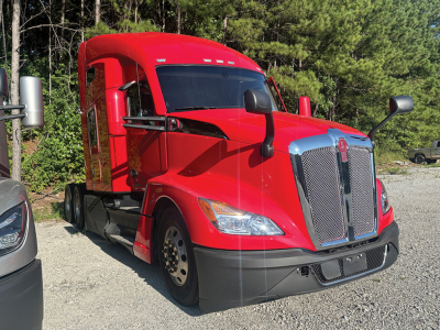 Kenworth T680 Next Gen tractor in red, front-left view with chrome grille and black bumper.