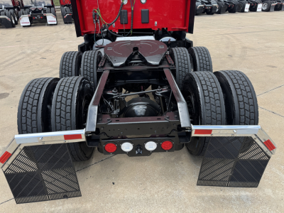 Kenworth T680 rear view showing dual rear axles and mudflaps, chassis components, and fuel/air lines under the sleeper cab.