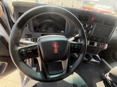 Kenworth T680 interior view showing steering wheel with KW logo, dashboard and control panels.