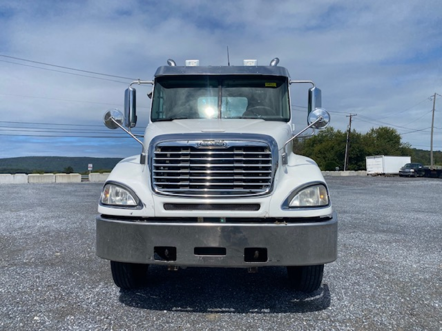 Front view of a white 2007 Freightliner Columbia CL120ST conventional daycab truck showing large chrome grille, bumper, and headlights.