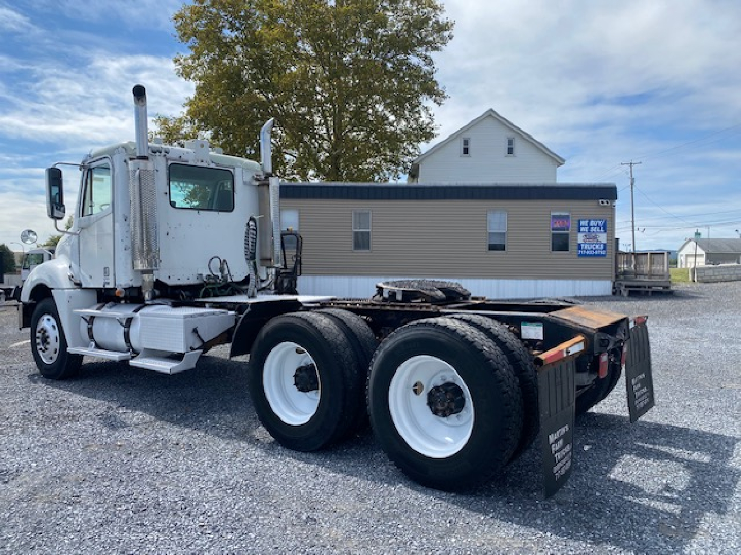 Freightliner Columbia CL120ST conventional daycab tractor showing rear dual tires and bare chassis with fuel tanks and exhaust stack.