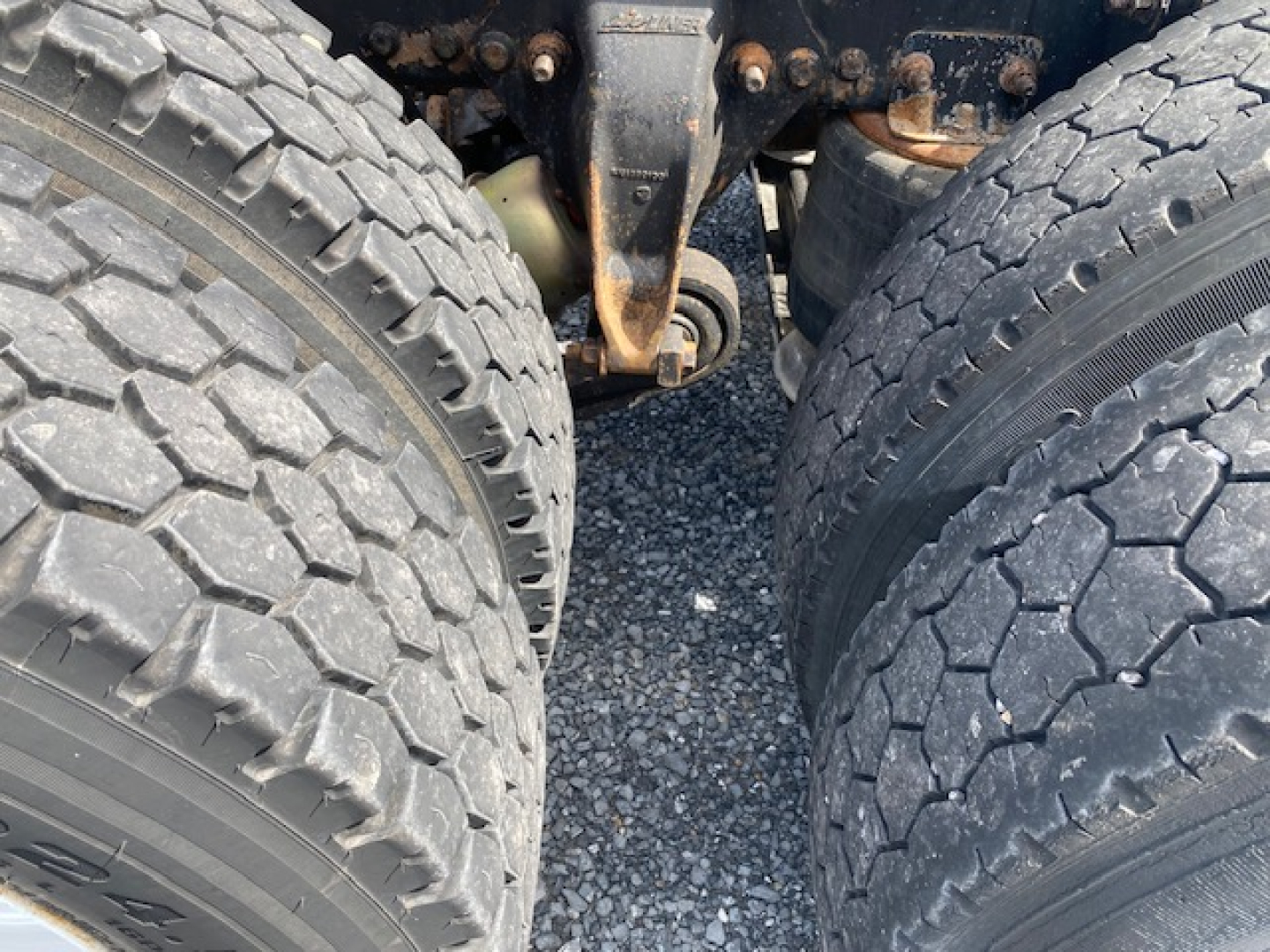 Freightliner heavy truck rear dual wheels and suspension components visible, with dual tires and hub area; no surrounding labels readable.