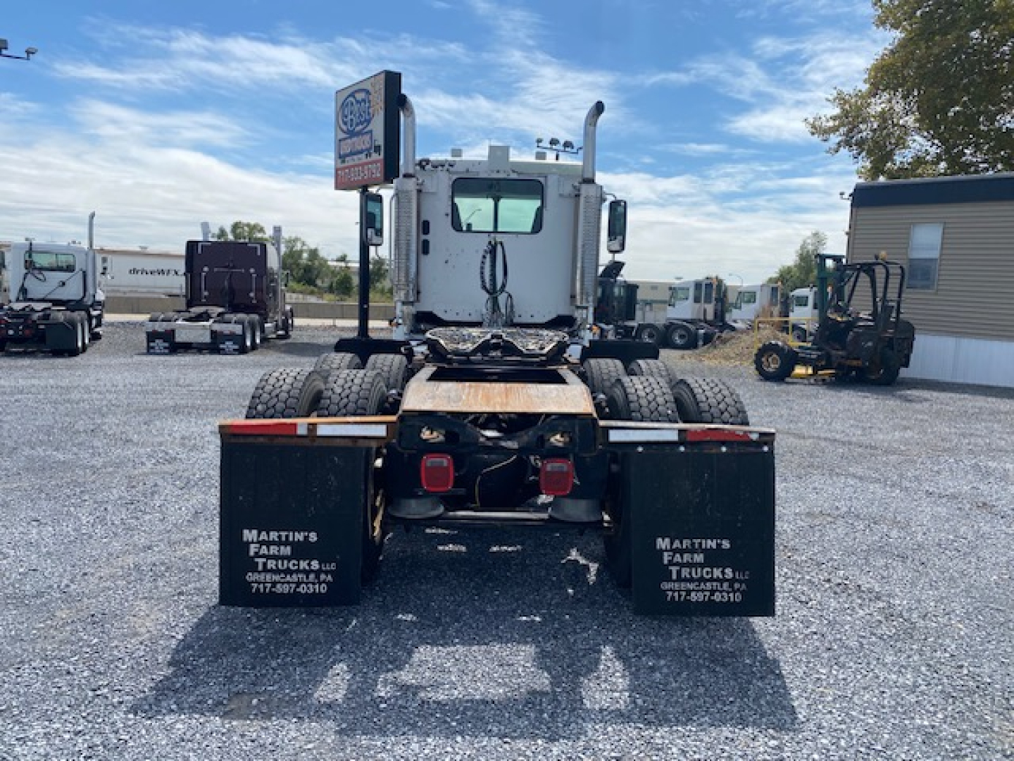 Rear view of a Freightliner Columbia tractor cab showing dual rear fenders with white text; mud flaps read MARTIN'S FARM TRUCKS, GREENCASTLE PA; chassis and fifth wheel area visible.