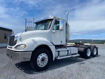 Freightliner Columbia CL120ST tractor truck in white, side view showing cab, exhaust stack, dual rear axles, and chrome bumper.