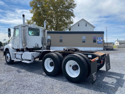 Freightliner Columbia CL120ST conventional daycab tractor showing rear dual tires and bare chassis with fuel tanks and exhaust stack.