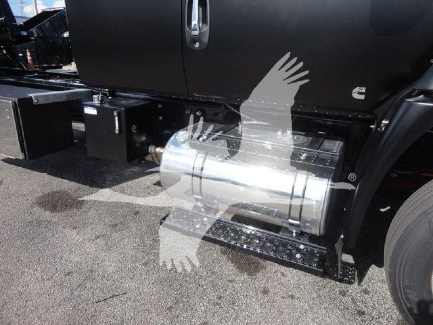 Truck side view showing cylindrical stainless steel fuel tank under the cab of a new International MV rollback truck.