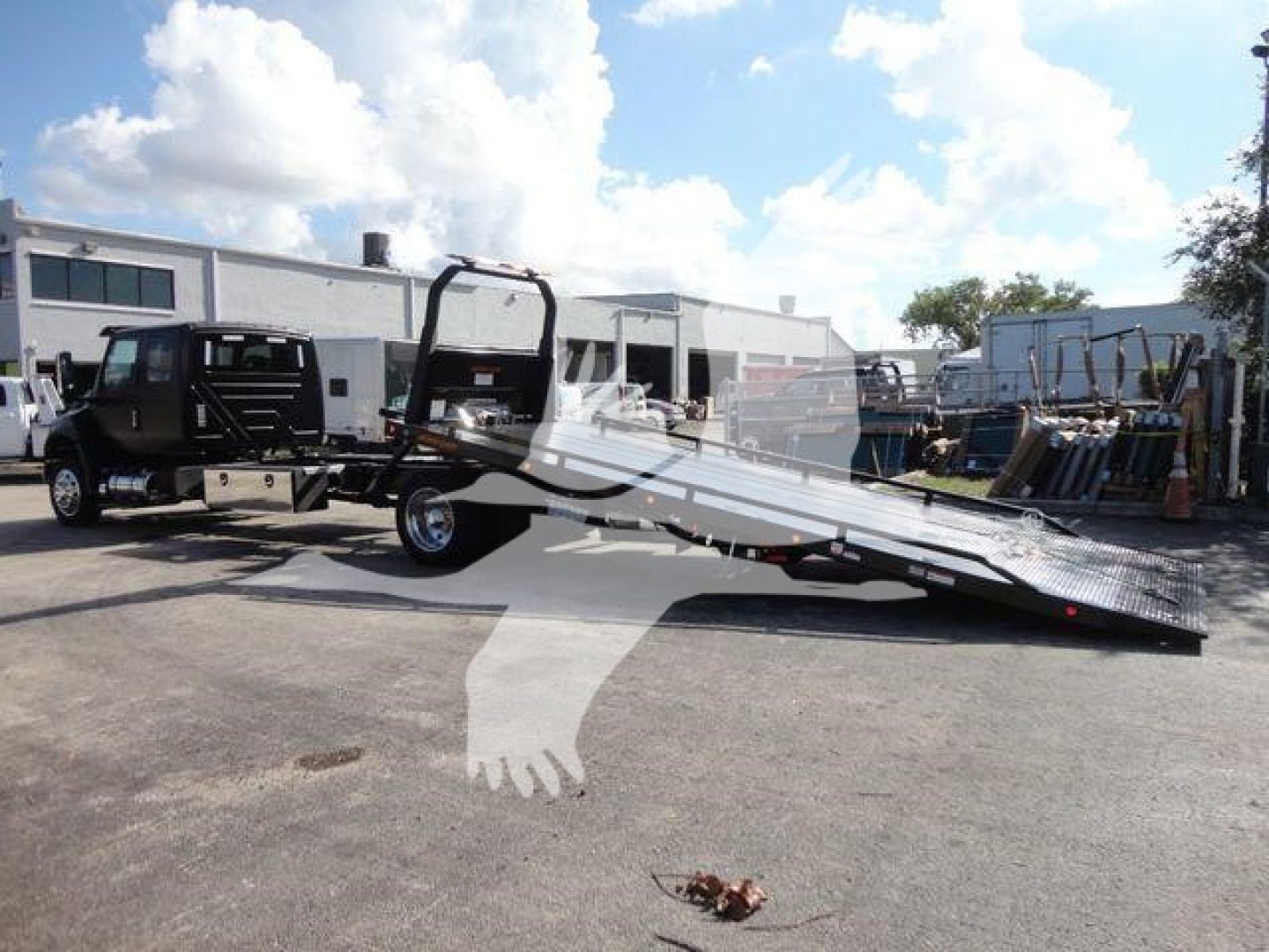 2027 International MV rollback truck with flatbed tow trailer in a dealership lot, side view showing extendable ramp, cab and chassis, stock J47176.