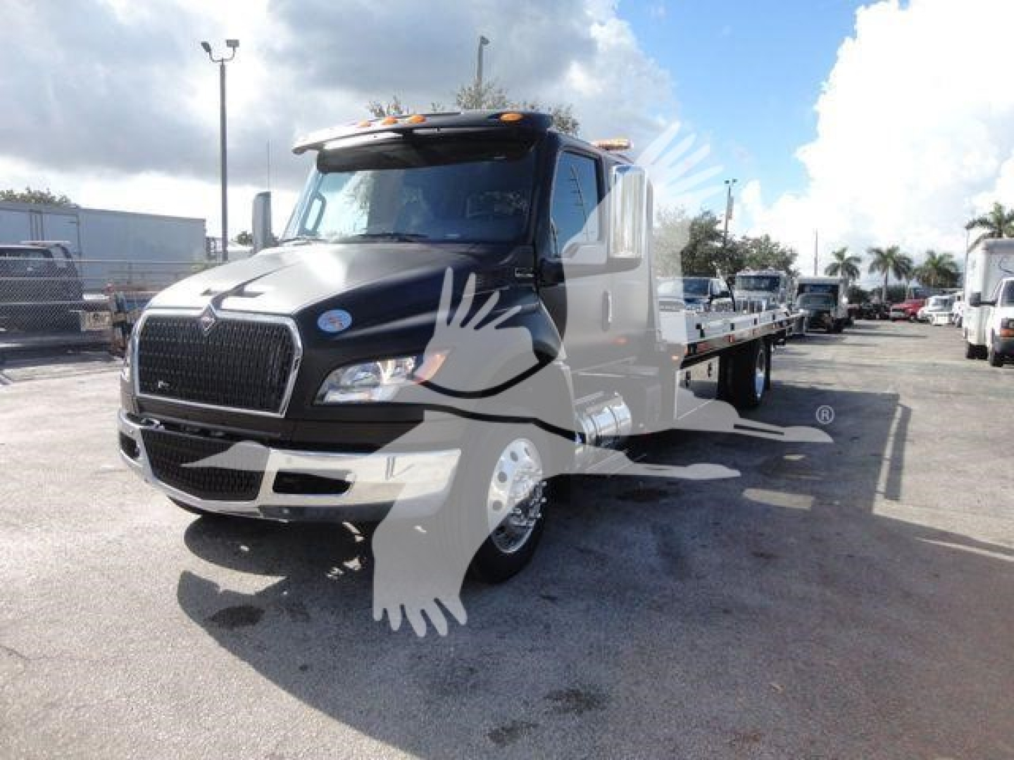 International MV rollback truck in front view showing cab details and flatbed w/ wheel on the right, stock number J47176.