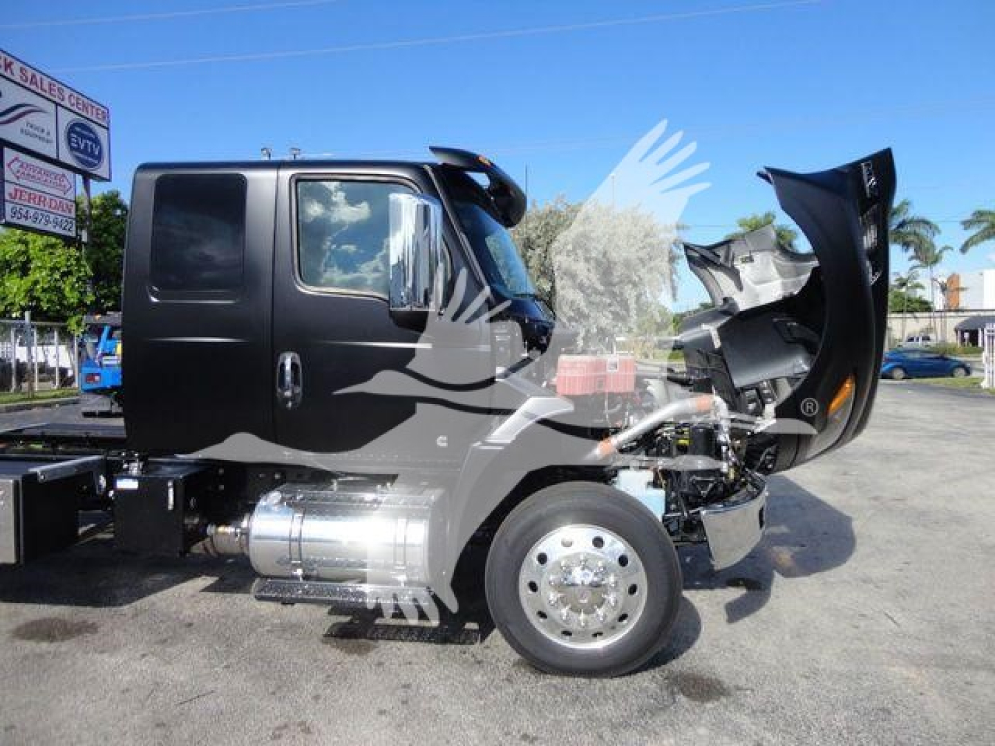 Truck with hood open showing engine bay and side cab of a new 2027 International MV rollback truck.
