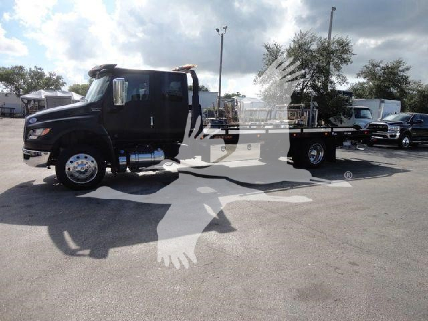 International MV rollback truck in view showing cab and chassis with flatbed.