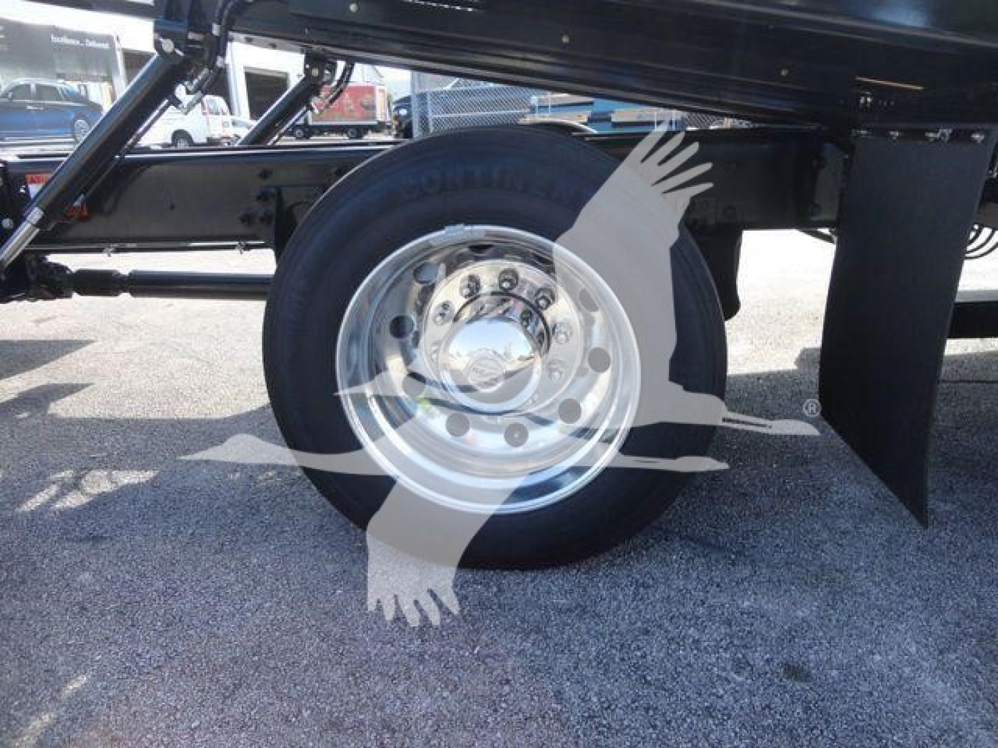 Truck wheel and suspension view showing a shiny steel wheel and black undercarriage components.