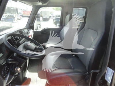 Truck cab interior showing steering wheel, driver's seat, and dashboard of a 2027 International MV rollback truck.