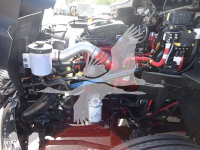 Image shows engine bay of a new International MV rollback truck with visible hoses, filters, and electrical components.