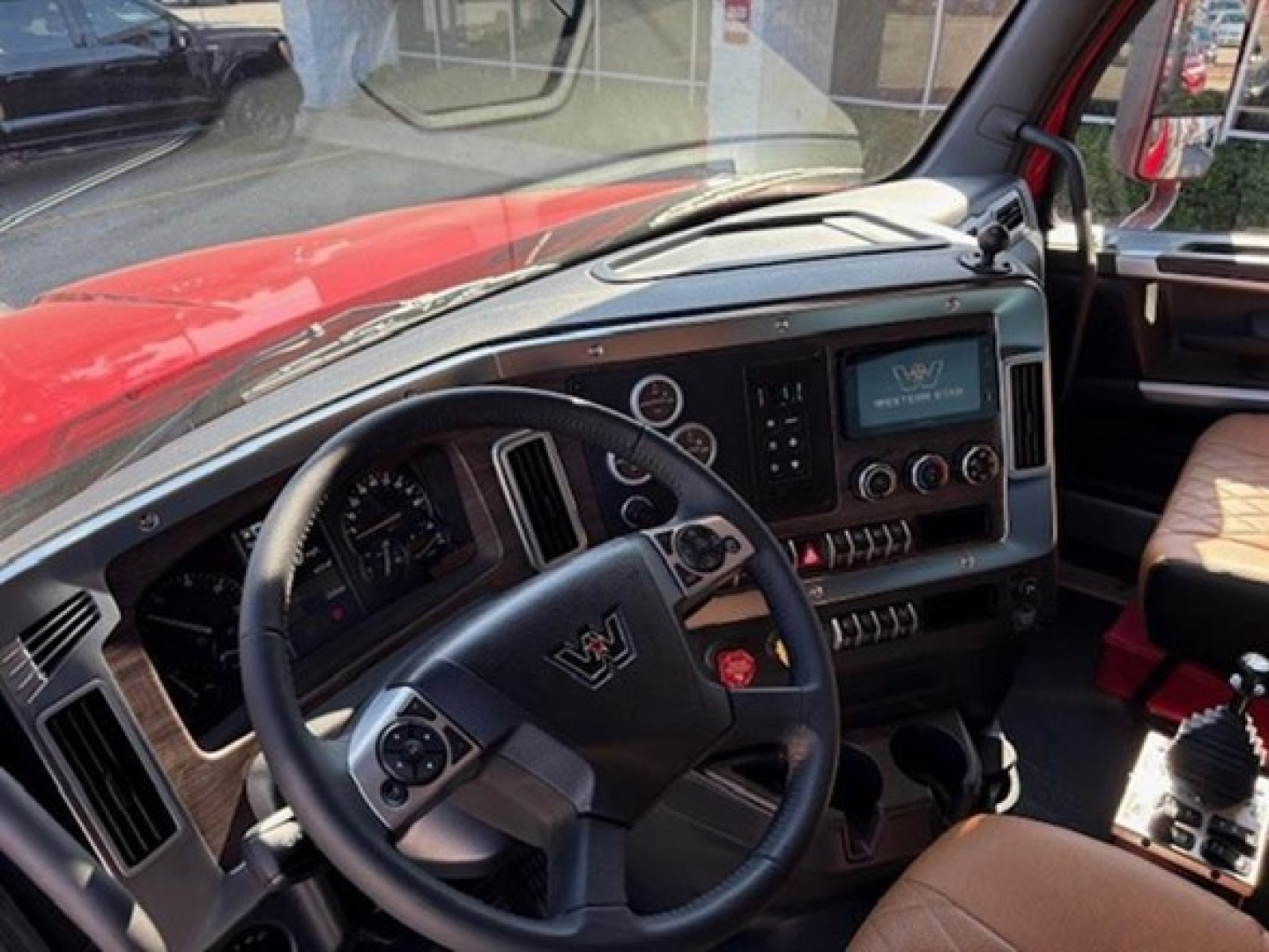 Interior view of a Western Star 49X truck cabin showing steering wheel, dashboard, and touchscreen infotainment.