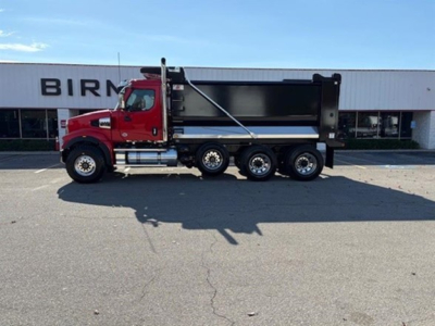 Western Star 49X dump truck side view showing red cab and black dump bed.