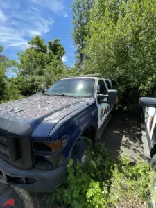 Ford F-250 Super Duty police vehicle with cap, front-left view, showing partial door decal and cruiser markings.