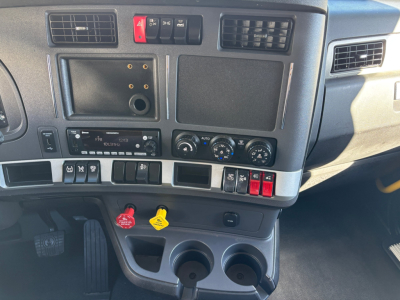 Kenworth T680 dash and center console showing controls, cup holders, and dashboard switches.