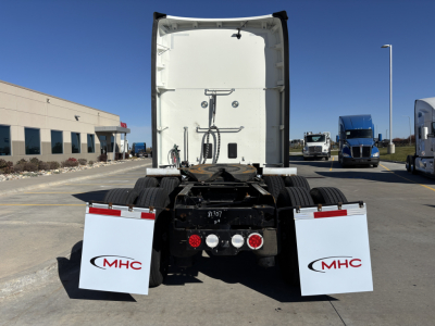 Kenworth T680 rear view showing fifth wheel, dual rear axles, and white MHC mud flaps with red MHC logos