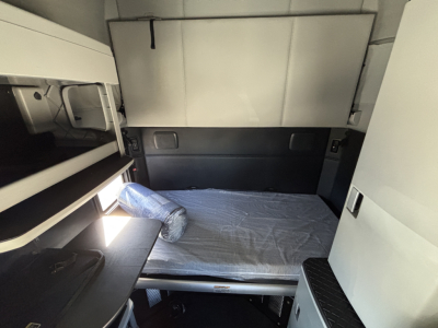 Kenworth T680 sleeper cab interior showing bunk bed area with mattress and storage compartments