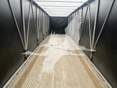 Trailer interior showing a curtainside trailer cargo area with ribbed floor and black side walls.