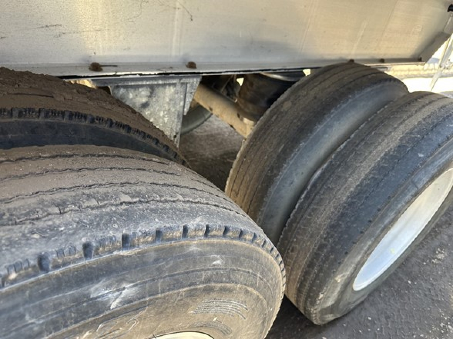 Dual-tire trailer axle view with visible tires and undercarriage; no readable model text in image.