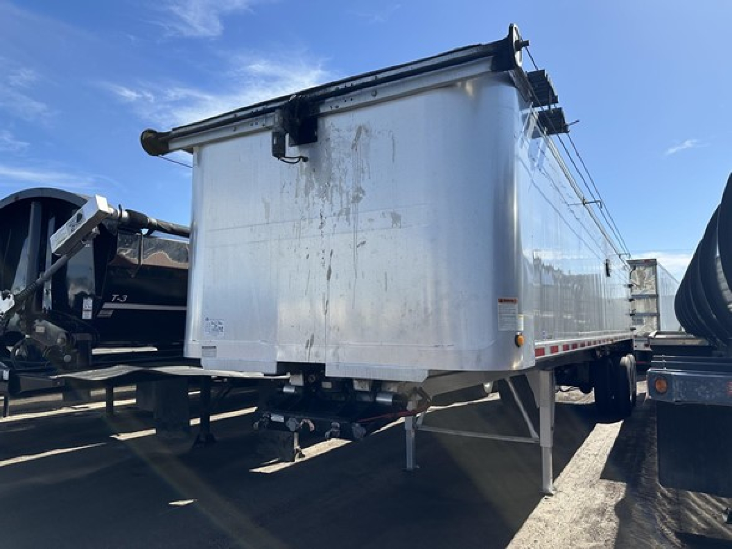Dump trailer side view showing white steel bed and support legs labeled with 7