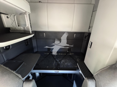 Kenworth T680 sleeper cab interior cargo area with storage compartments and bed area visible.