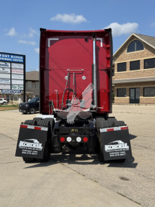 Kenworth T680 rear view showing red sleeper cab and black chassis with mud flaps and rear bumper.