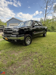 Chevrolet Silverado 1500 extended cab pickup truck in black parked on grass with house in background