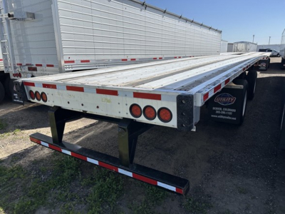 Transcraft spread air combo flatbed trailer showing dual rear lights, reflective tape, and aluminum deck.