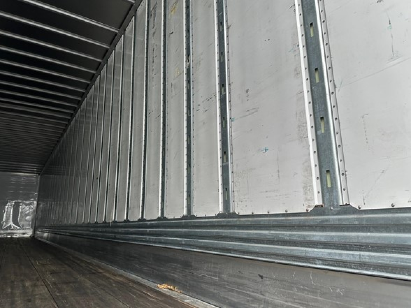 Utility 4000Dx trailer interior showing corrugated metal sidewalls and floor with lighting rafter at ceiling.